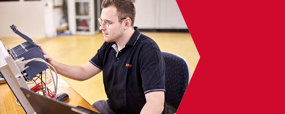 Ein junger Mann arbeitet an einem Bildschirm und einem Steuerungsmodul