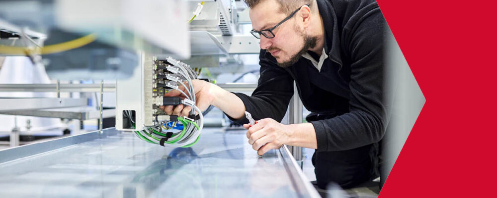 Mann arbeitet an der Verdrahtung verschiedener Komponenten in modernem Produktionsumfeld
